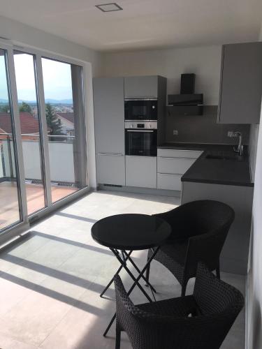 a kitchen with a table and chairs in a room at Apartment Sun Lakes pri Aquaparku in Senec