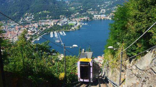 a train traveling down a hill next to a body of water at Casa di Princi in Brunate