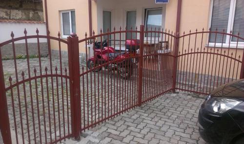 a red fence with a motorcycle parked in front of a house at City Center Apartments Ohrid in Ohrid