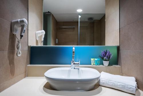a bathroom with a sink and a mirror at Angela Downtown Hotel in Rhodes Town