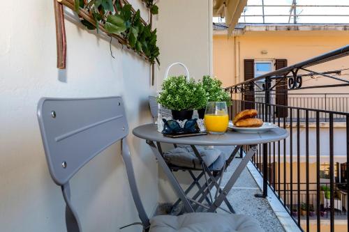 a table on a balcony with a glass of orange juice at Euphoria apartment in Corfu Town