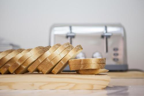 un grupo de palitos de pan en una tabla de cortar junto a una tostadora en BluRiva Hotel, en Cirò Marina