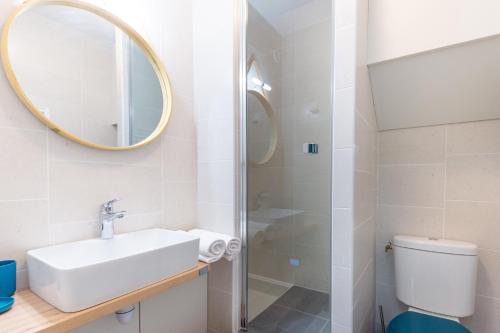 uma casa de banho com um lavatório e um chuveiro com um espelho. em L'Ourson des Myrtilles em La Bresse