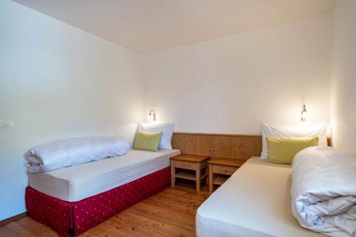 Duas camas num pequeno quarto com almofadas brancas e verdes em Naturresidenz Theistadl Apt 102 em Pracupola