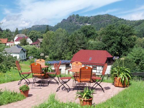 a group of chairs and tables on a patio at Ferienpension Gabriele 15 in Kurort Gohrisch