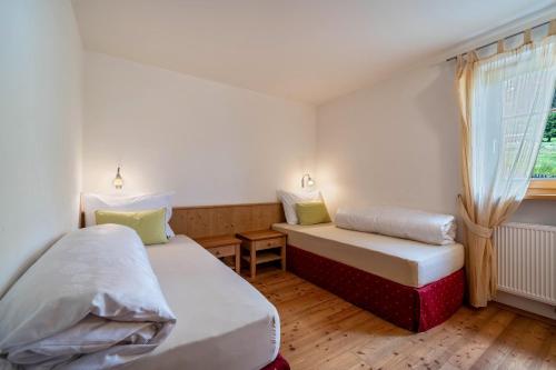 twee bedden in een kleine kamer met een raam bij Naturresidenz Theistadl Apt 101 in Pracupola