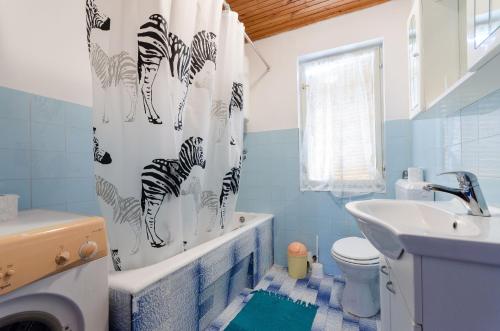 ein Bad mit einem Zebra-Duschvorhang und einem Waschbecken in der Unterkunft Apartments Opsenica in Barbat na Rabu