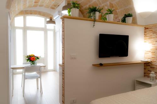 sypialnia z łóżkiem i telewizorem na ścianie w obiekcie La Loggia del Buon Tempo w mieście Polignano a Mare