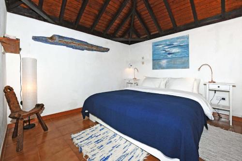 a bedroom with a bed and a chair in a room at Casa Nonito in Tijarafe