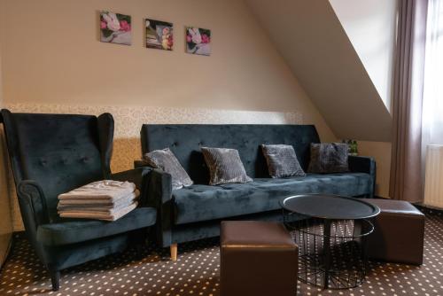 a living room with a blue couch and a chair at Medical Wellness & SPA Werona in Duszniki Zdrój
