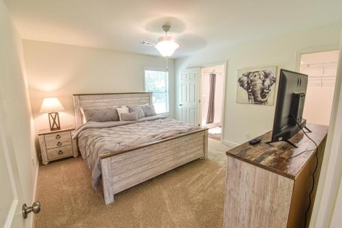 a bedroom with a bed and a flat screen tv at Charming & Comfy - Close to Stadium & Campus - Parents - Game Weekend in Tuscaloosa