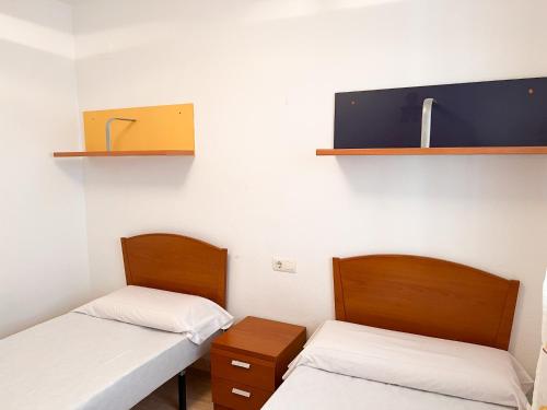 two beds in a hospital room with shelves at Apartamento Deluxe Jardín in Oropesa del Mar