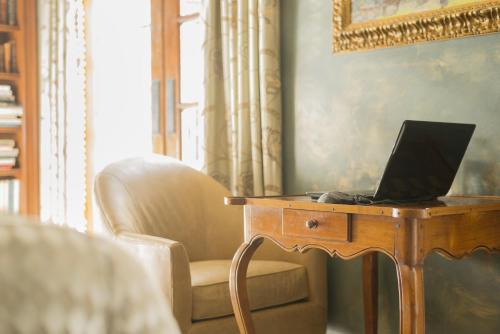 a laptop sitting on a wooden table next to a chair at Ayres Hotel Manhattan Beach in Hawthorne