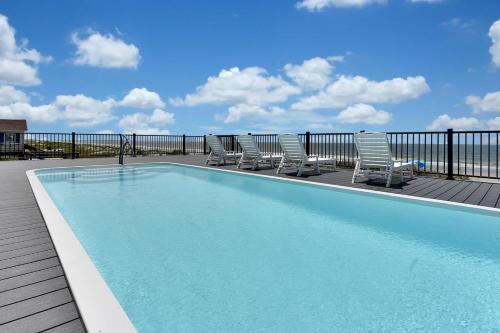 a swimming pool on a deck with chairs around it at Saltwater Gospel in Oak Island