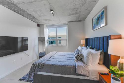a bedroom with a bed and a large window at Lovely Condo At Midtown Miami with pool in Miami