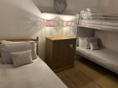 a small bedroom with two bunk beds and a dresser at Coastal Chalet Retreat in St Margaret's Bay in St Margarets at Cliff