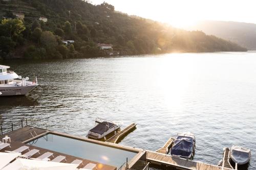 two boats are docked at a dock on a lake at Douro Hotel Porto Antigo in Cinfães