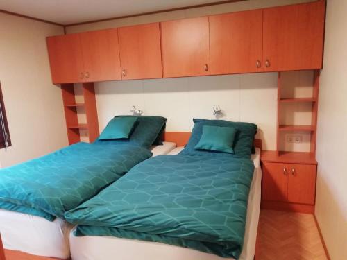 two beds in a room with wooden cabinets at Chalet Knut in Osterode