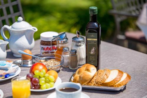 a table with a bottle of wine and a plate of bread and fruit at B&B Marijana in Malinska