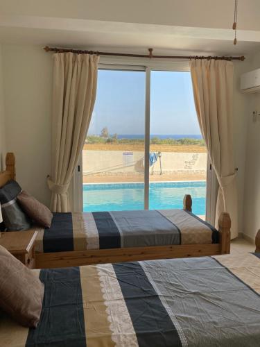 a bedroom with two beds and a view of the beach at Coral Bungalow in Coral Bay