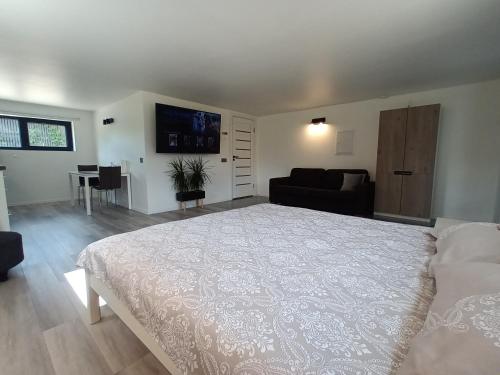 a bedroom with a large white bed and a couch at Luxury Apartment Private House and Parking Netflix in Tartu