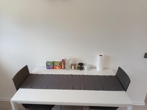 a white table in a room with a white wall at Luxury Apartment Private House and Parking Netflix in Tartu