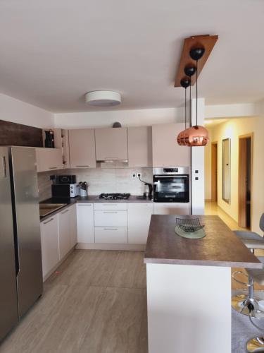 a kitchen with white cabinets and a stainless steel refrigerator at Skitnica Prestige in Koprivnica