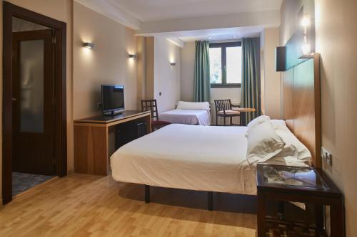 a hotel room with a bed and a television at Silken Ordesa in Torla