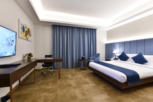 a hotel room with two beds and a television at JUFFAIR BOULEVARD HOTEL & SUITES in Juffair