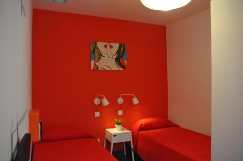 a red room with two beds and a painting on the wall at Falow in Las Palmas de Gran Canaria