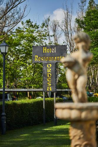 a sign for a hotel restaurant and a statue at Silken Ordesa in Torla