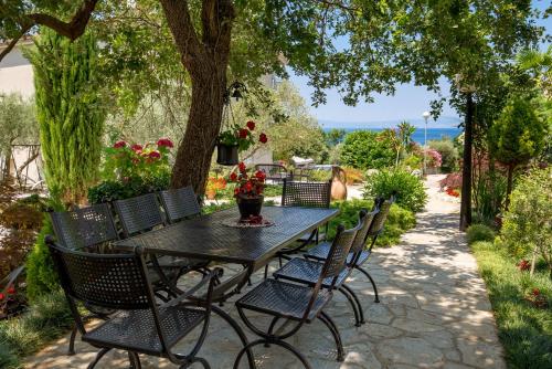 a black table and chairs with a vase of flowers on it at B&B Marijana in Malinska