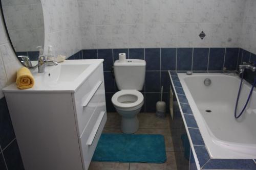 een badkamer met een wastafel, een toilet en een bad bij Happy hippies House in Sainte-Rose
