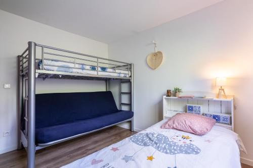 a bedroom with a bunk bed with a blue bedspread at Can Guillamou in Serralongue