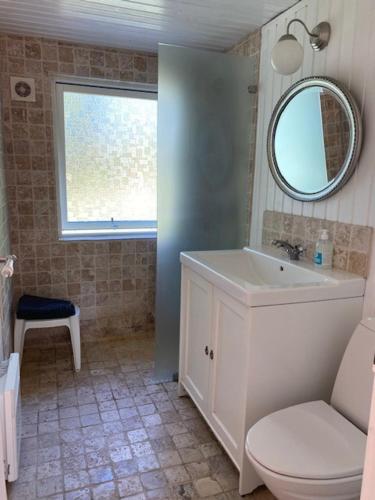 uma casa de banho com um lavatório, um WC e um espelho. em Sommerhus - Bratten strand em Jerup