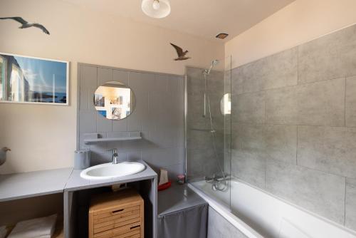 een badkamer met een wastafel en een douche bij L'Atelier du Pêcheur in Fécamp