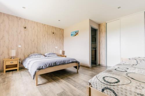 1 dormitorio con 2 camas y pared en L'Escapade à la Banut, en Jallandrieu