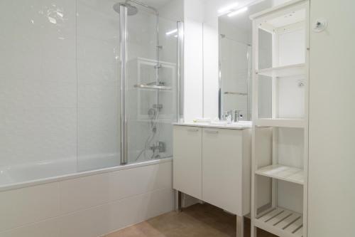 een witte badkamer met een douche en een wastafel bij Les Merisiers in Lorgues