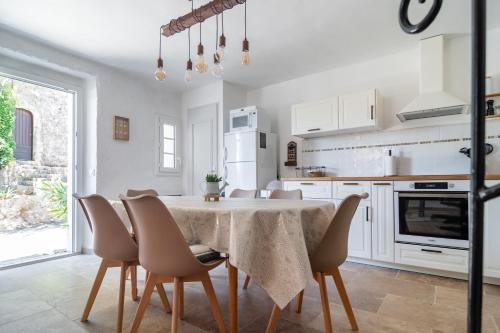 une cuisine blanche avec une table et des chaises dans l'établissement Saint Bernard, à Fox-Amphoux