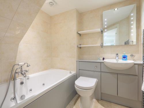 Un baño con bañera, inodoro y lavabo. en Keepers Lodge, Hillfield Village, en Dartmouth