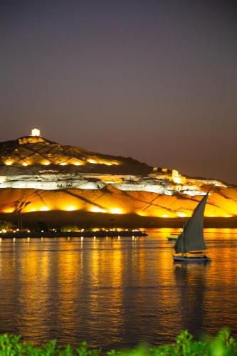 a sailboat in the water in front of a building at Go Inn Backpackers in Aswan
