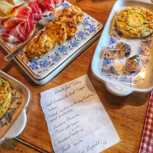 a table topped with plates of food and a menu at B&B Dove Comincia la Bella Italia in Beura
