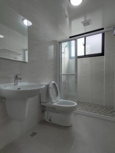 uma casa de banho branca com um WC e um lavatório em 礁溪幸福民宿Jiaoxi Happy Homestay em Jiaoxi