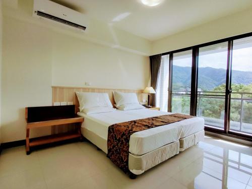 um quarto com uma cama grande e uma janela grande em 礁溪幸福民宿Jiaoxi Happy Homestay em Jiaoxi