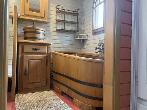 y baño con bañera de madera y lavamanos. en Roulotte en bois Sud France, en Le Soler