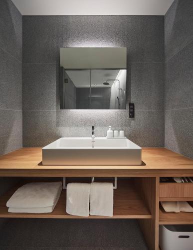 a bathroom with a white sink and a mirror at MUJI HOTEL GINZA in Tokyo