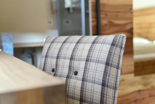 a plaid chair sitting in front of a table at Hotel Naturoase Schwemmerhof in Ultimo