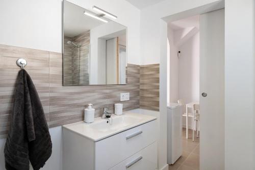 Un baño blanco con lavabo y espejo. en Noaian, en Puerto del Carmen