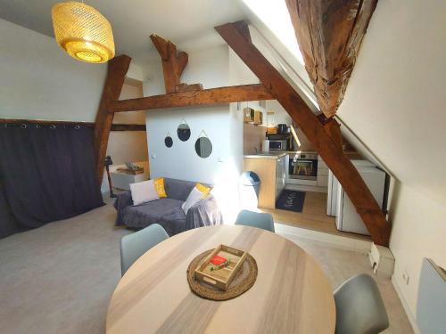 sala de estar con mesa y sillas en una habitación en Le Capucin Serein en Coulommiers