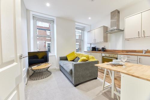 a kitchen and living room with a couch and a table at Penshaw Boutique Apartment in Sunderland